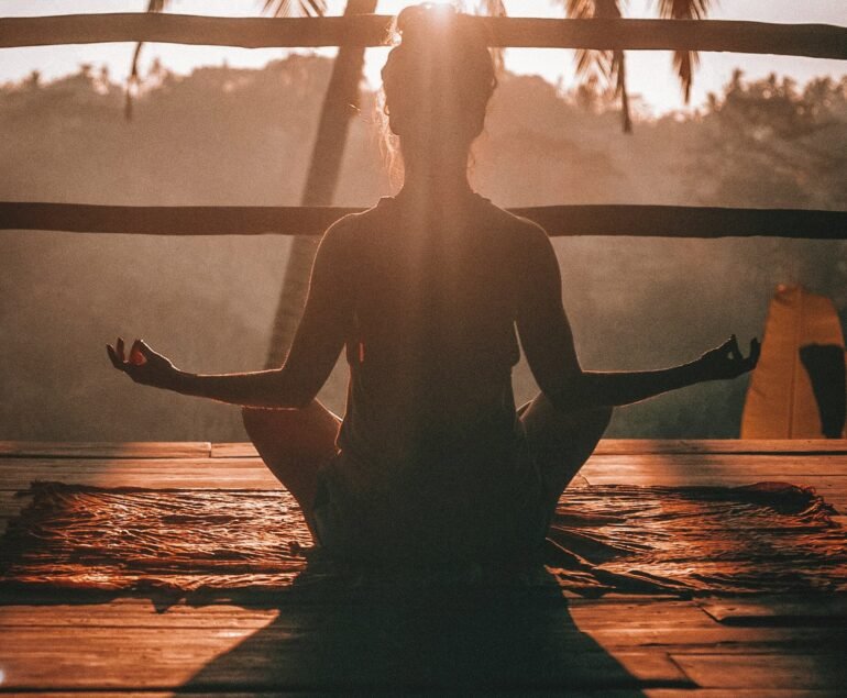 woman doing yoga meditation on brown parquet flooring