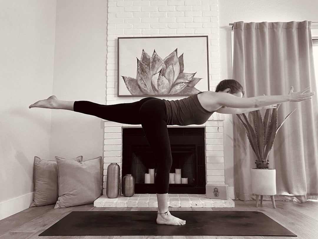 Woman in warrior yoga pose in bright studio for weight loss