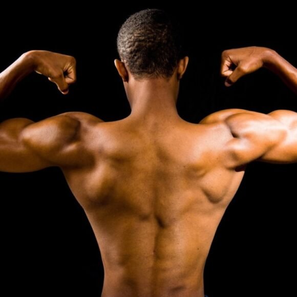 Triceps Muscle Exercise: 8 Best Moves for Size and Definition Person flexing triceps muscles showing defined arm workout results