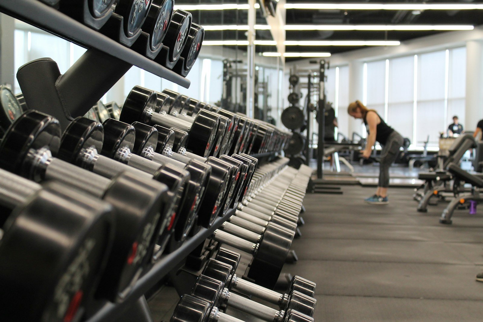 Woman over 40 doing weight training with dumbbells at home
